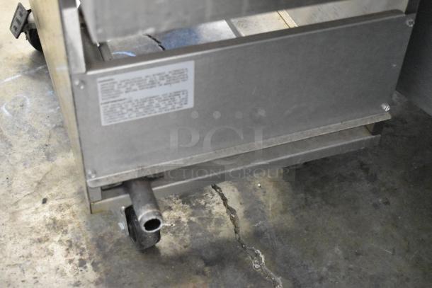 Royal REEF-35 Stainless Steel Commercial Deep Fat Fryer with 2 metal baskets on casters, natural gas powered, label visible.