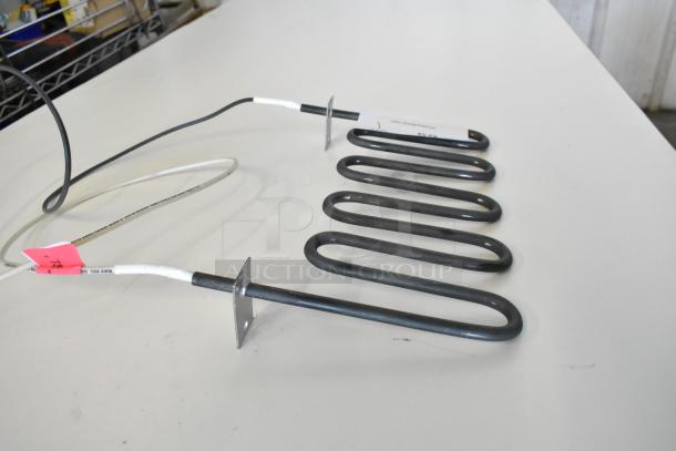 Brand new burner with scratch and dent. Includes white and black wires connected to metal coil. Pink tag visible.