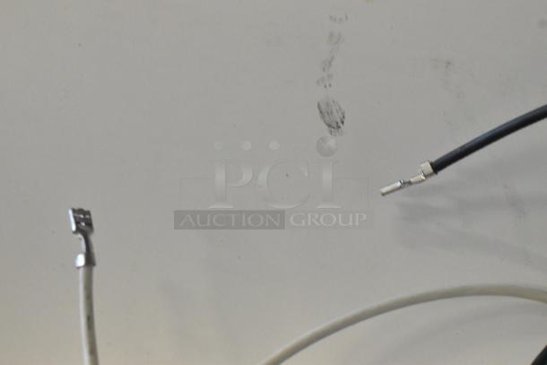 Brand new burner with visible scratches and dents, featuring connected wiring. Suitable for repair projects.
