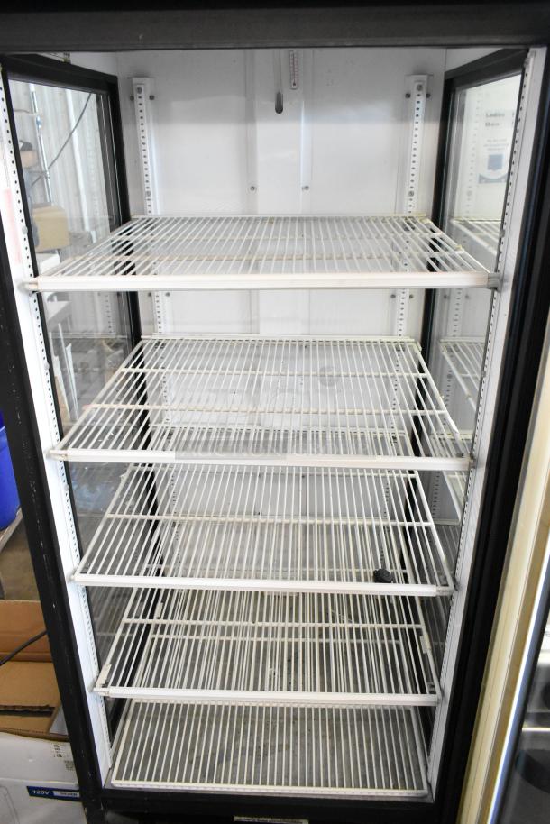 True GEM-26 metal commercial cooler with single glass door, featuring poly-coated racks. 115V, 1 phase; interior view, excellent condition.