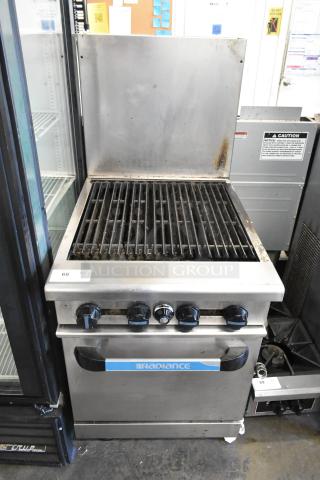 Radiance stainless steel commercial gas charbroiler grill with oven, back splash, and casters. Shows some wear.