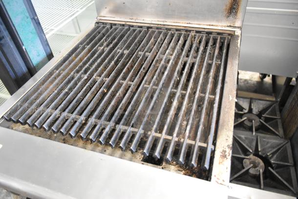 Radiance stainless steel commercial gas charbroiler grill with oven, backsplash, and commercial casters; used condition.