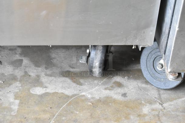 True TWT-60F stainless steel commercial 2-door work top freezer on casters, 115 volts, 1 phase, some surface wear visible.
