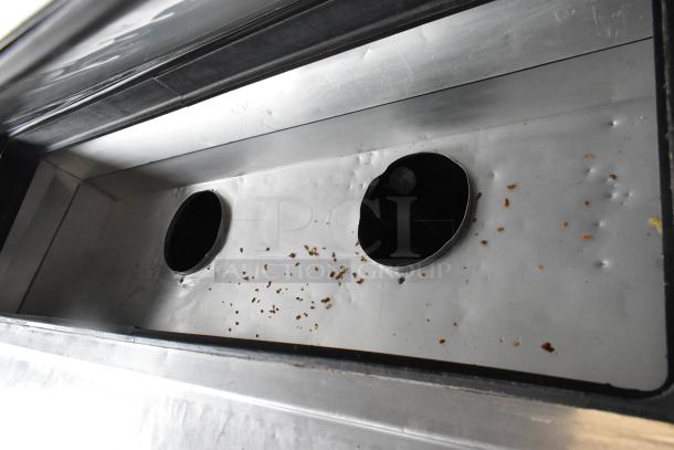 2017 True TPP-67 stainless steel commercial pizza prep table interior with ingredient residue, indicating use.