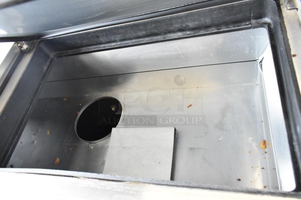 2017 True TPP-67 stainless steel commercial pizza prep table interior, slight signs of use, with integrated utensil holder.