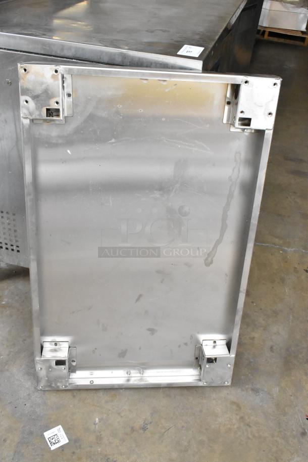 Stainless steel panel with mounting brackets, slight surface scratches, and marks; ideal for industrial or commercial use.