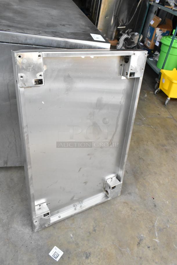 Stainless steel panel with mounting brackets, rectangular shape, minor surface wear, suitable for industrial use.