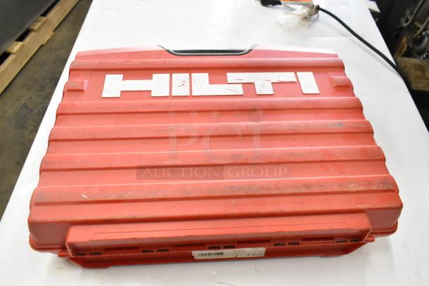 Red Hilti tool box showing the Hilti logo, part of a lot including various power tools. Marks indicate previous use.