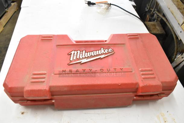 Milwaukee heavy-duty red tool case, slightly worn, with embossed logo. Contains various power tools including Hilti, DeWalt, Bosch.