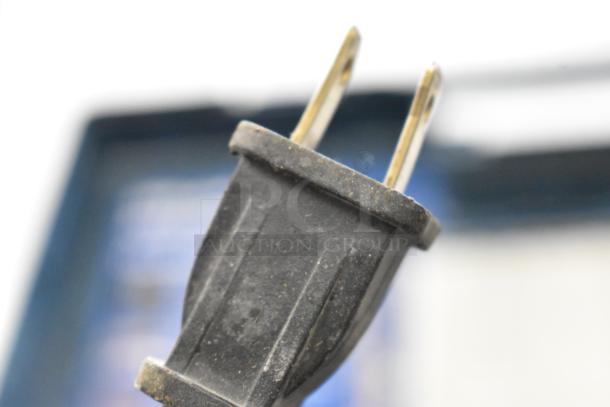 Close-up of a dusty plug from one of the auctioned power tools, highlighting wear and electrical connection.
