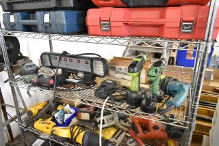 Auction items on metal shelves include Roto Zip DR1, Hitachi SV12SG Sander, Hitachi DS12DVF3 Drill, Winplus Power Station, and more.