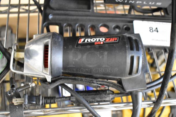 Roto Zip DR1 tool with cord and attachments on shelf, showing brand logo. Part of a nine-item auction bundle.
