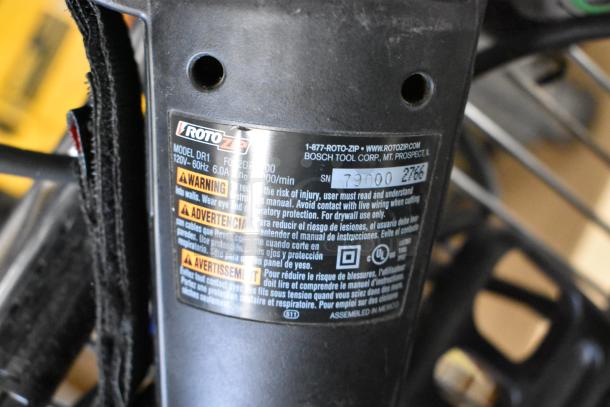 Roto Zip DR1 detail with model label, 120V, 60Hz, 6.0A, warning instructions in multiple languages, serial number visible.