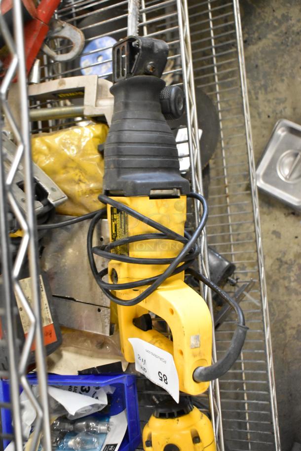 DeWalt DW304 reciprocating saw on metal shelf, used condition, tangled cord visible, surrounded by various tools and items.