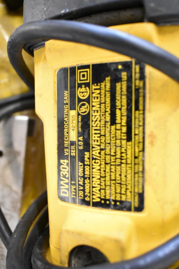 Close-up of DeWalt DW304 reciprocating saw showing label with specs: 120V, 6.0A, 0-2400/0-1800 SPM, Serial 42755.