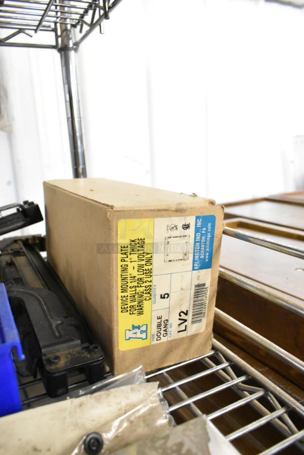 Box labeled "Device Mounting Plate" for low-voltage use, double gang, quantity 5 by Arlington Ind., Inc. on a shelf.