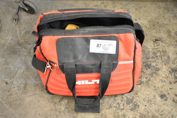 Hilti tool bag with black straps, visible contents include clamps, condition appears used. Auction tag 87 attached.
