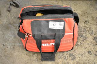 Hilti tool bag with black straps, visible contents include clamps, condition appears used. Auction tag 87 attached.