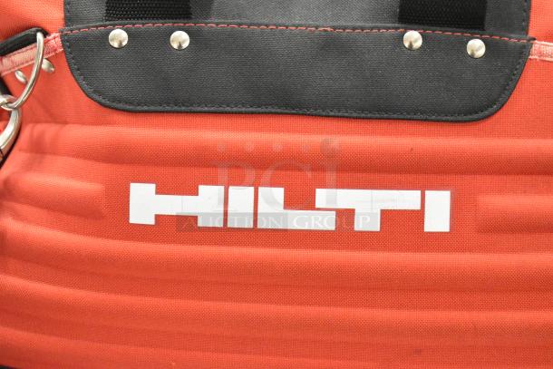 Hilti red tool bag with contents including clamps. Durable fabric, black trim, and branded logo. Ideal for professionals.