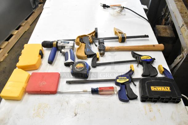 Hilti tool bag with contents including various clamps, DeWalt cases, Kobalt drill, tape measure, and a Craftsman screwdriver.