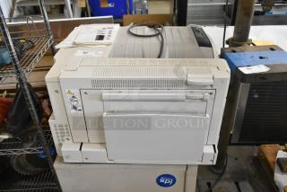 Two Xerox Phaser 7500 printers, off-white, with visible condition wear. Includes printed labels on top. Auction item.