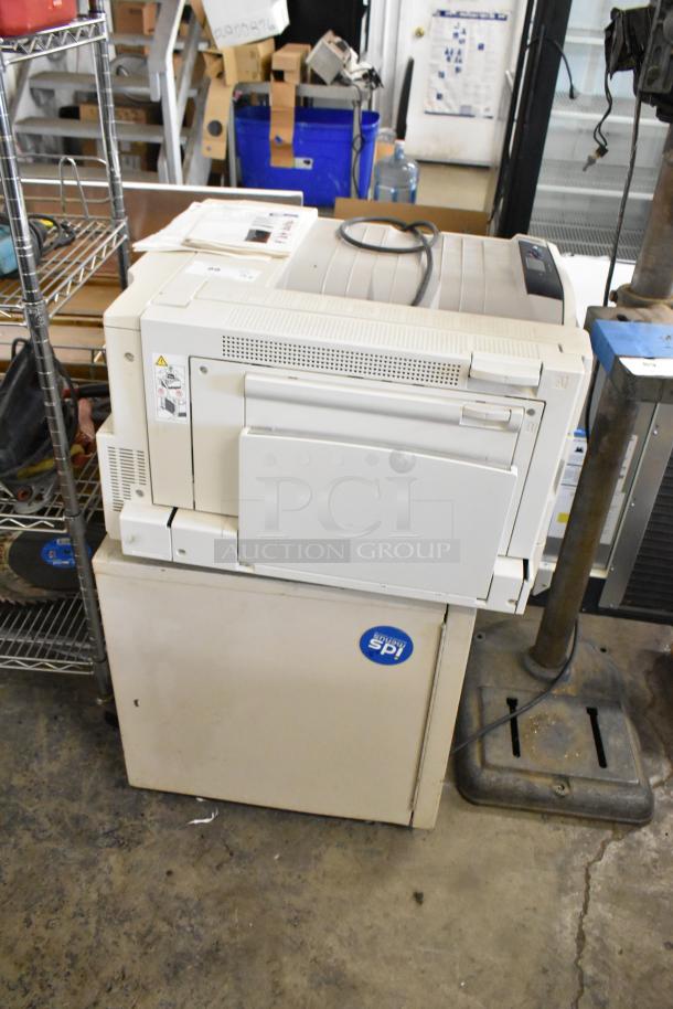 Two Xerox Phaser 7500 printers, used condition, stacked in an industrial setting. Includes visible power cables.