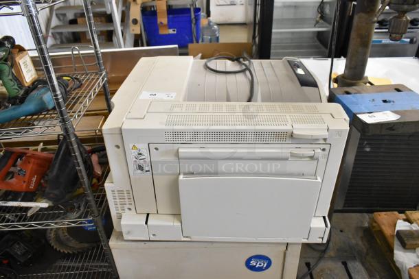 Two Xerox Phaser 7500 printers with visible power cables. Fair condition, used. Markings indicate model and warnings.