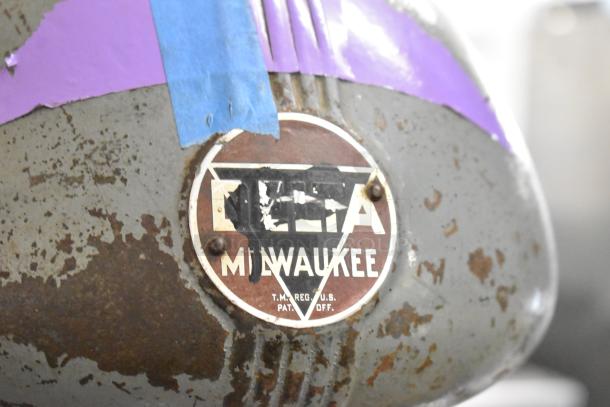 Vintage Delta/Milwaukee unit. Features 120V, 1-phase. Shows wear with rust on the metal and a faded logo.