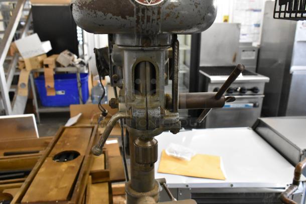 Delta/Milwaukee drill press, vintage condition, 120 volts, 1 phase, metal construction, manual controls visible.