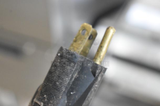 A close-up of a two-pronged electrical plug end.