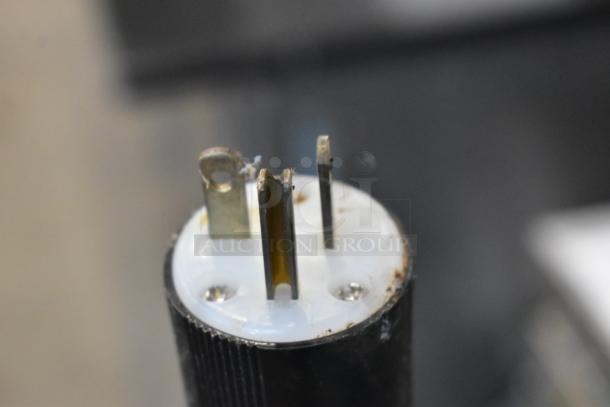 Close-up of the plug for the Hatco TQ-800HBA stainless steel commercial conveyor toaster oven, showing the metal prongs and some wear.