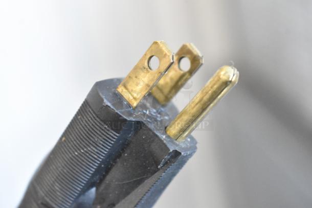 Close-up of a power plug with two brass prongs, part of the Silver King SKSD/C4 stainless steel commercial cooler.