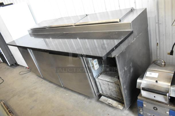 Delfield 18699PTT stainless steel commercial pizza prep table with cutting board, features commercial casters, 115V, 1 Phase.