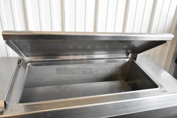 Delfield 18699PTT stainless steel pizza prep table with cutting board, lid open, on commercial casters, 115V, 1 phase.