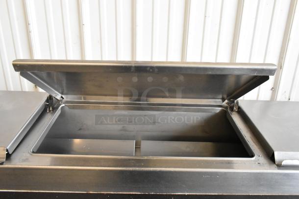 Delfield 18699PTT stainless steel pizza prep table, open lid view, with interior. Features cutting board, on casters, 115V, 1 Phase.