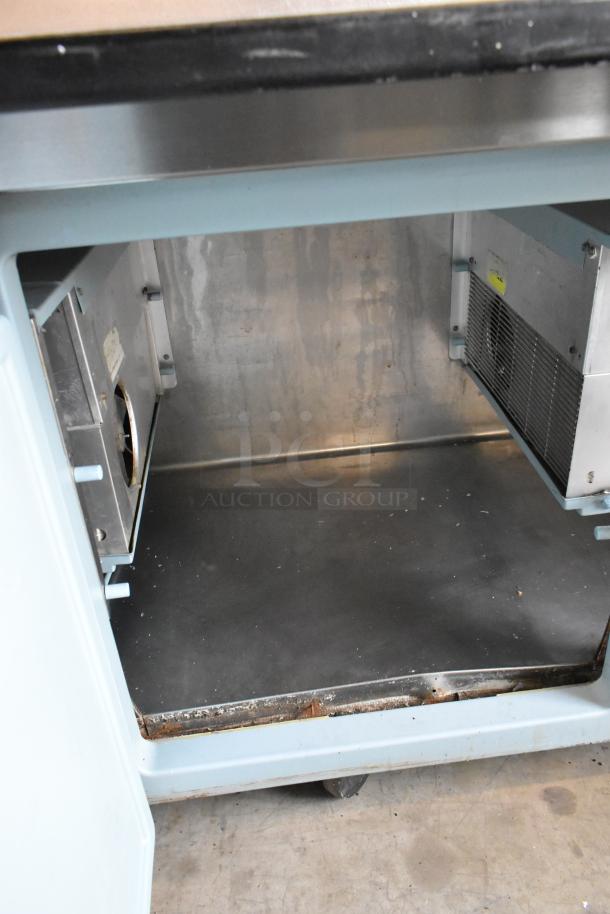 Delfield 18699PTT stainless steel pizza prep table interior, showing ample storage space and sturdy construction.