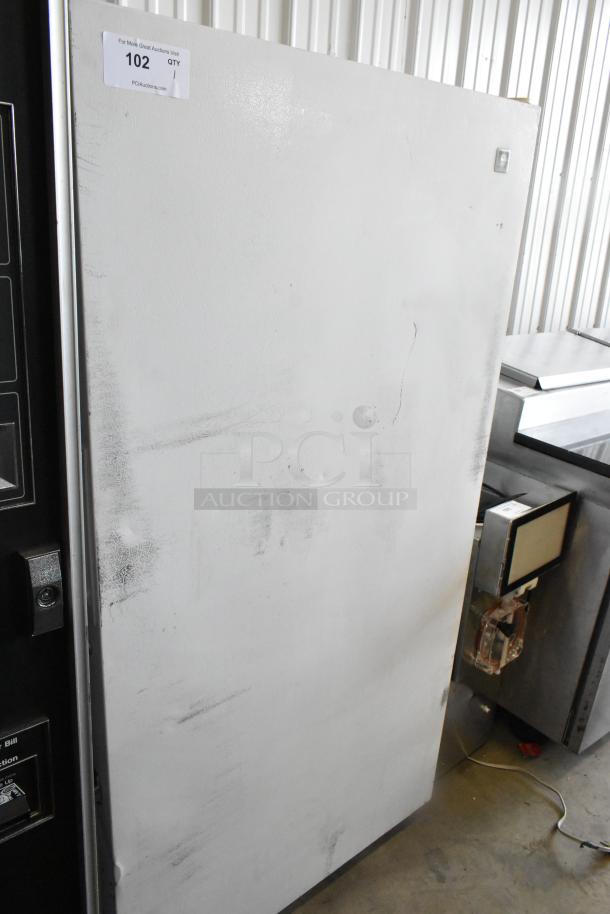 Maytag MQU2057AEW single door reach-in freezer. Visible wear. 115 volts, single phase. Auction tag reads "102".