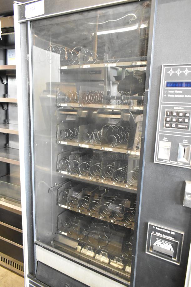 Metal commercial vending machine with key, featuring spiral dispensers and a digital keypad. Good condition. Model label: "103".