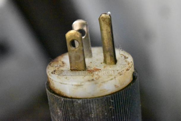 Close-up view of electrical plug for Oliver 702-N Bagel Slicer. Visible wear on metal prongs, indicative of moderate use.