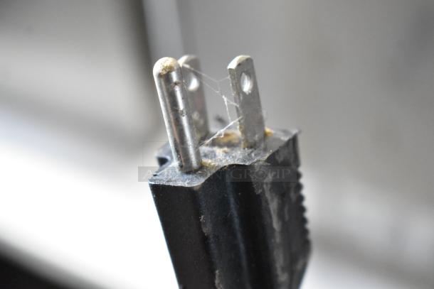 Close-up of a used electrical plug for an Oliver 702-N countertop bagel slicer, showing minor wear and dust.