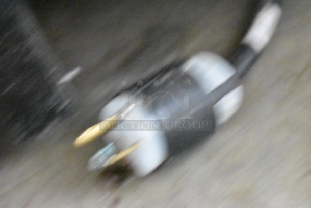 Blurry image of an electrical plug on a cable, related to a Hatco TQ-800HBA conveyor toaster oven.