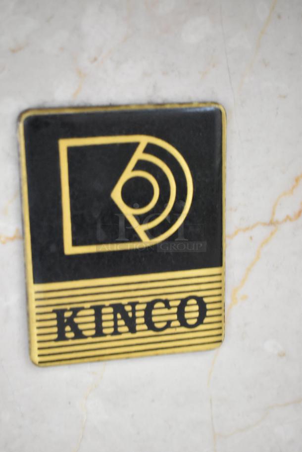 Kinco NSRM3 deli display case logo plate with black and gold design on metal surface. 110 Volts, 1 Phase.