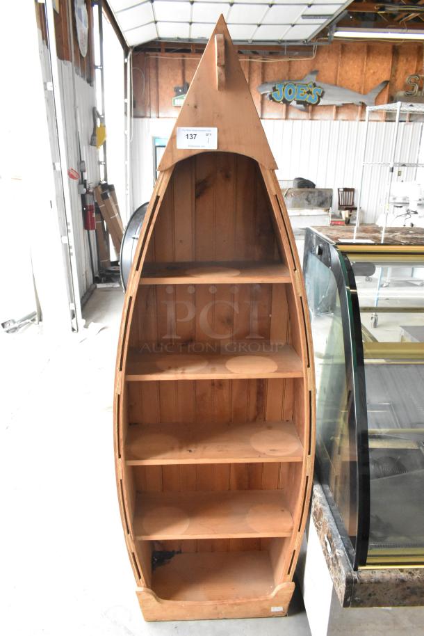Wooden canoe-shaped shelving unit with four shelves, natural finish, vertical design. Auction tag labeled "137."