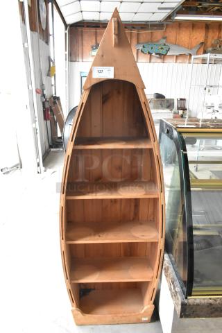 Wooden canoe-shaped shelving unit with four shelves, natural finish, vertical design. Auction tag labeled "137."