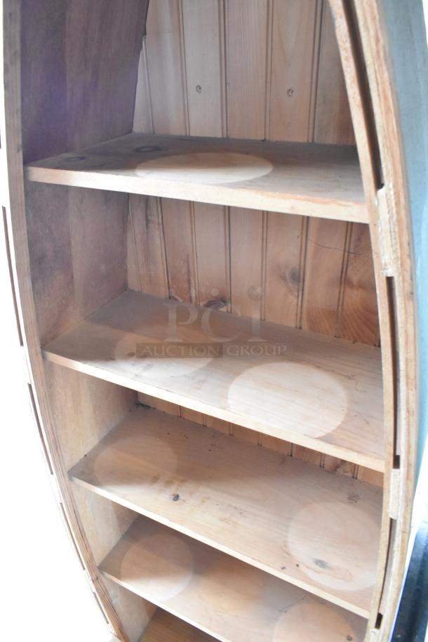 Wooden canoe-shaped shelving unit with four shelves, natural finish, visible wood grain, good condition, ideal for decor.