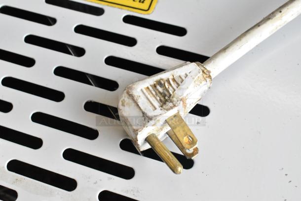 AHT Coolpoint CMV 50 mini cooler plug on white vented metal surface, showing signs of wear.