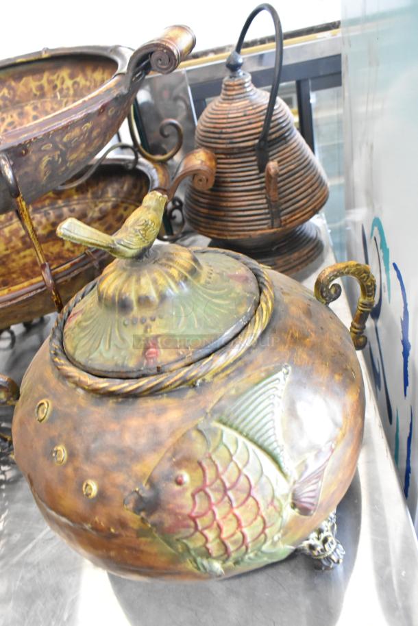 Nine decorative items; features ceramic vase with bird and fish motifs, various metal risers. Detailed, rustic appeal.
