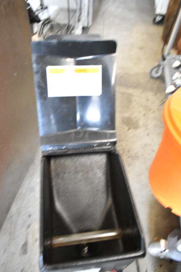 Bunn commercial coffee bean grinder, metal countertop model. 120 volts, single phase. Good condition with visible wear marks.