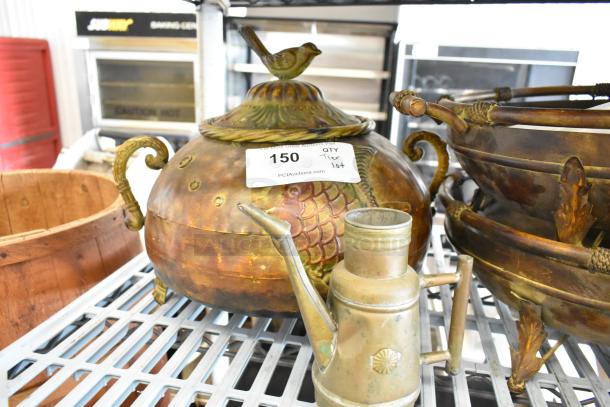 Bronze decorative chest with bird and leaf motifs, vintage watering can, and coated bowls. Lot tag reads "150 QTY Tier Lot".