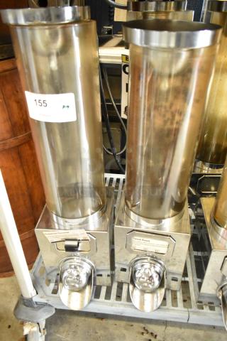 3 metal dry dispensers with clear cylindrical containers and stainless steel bases. Includes labels: "Hawaiian Coconut" and "French Roast." Good condition.